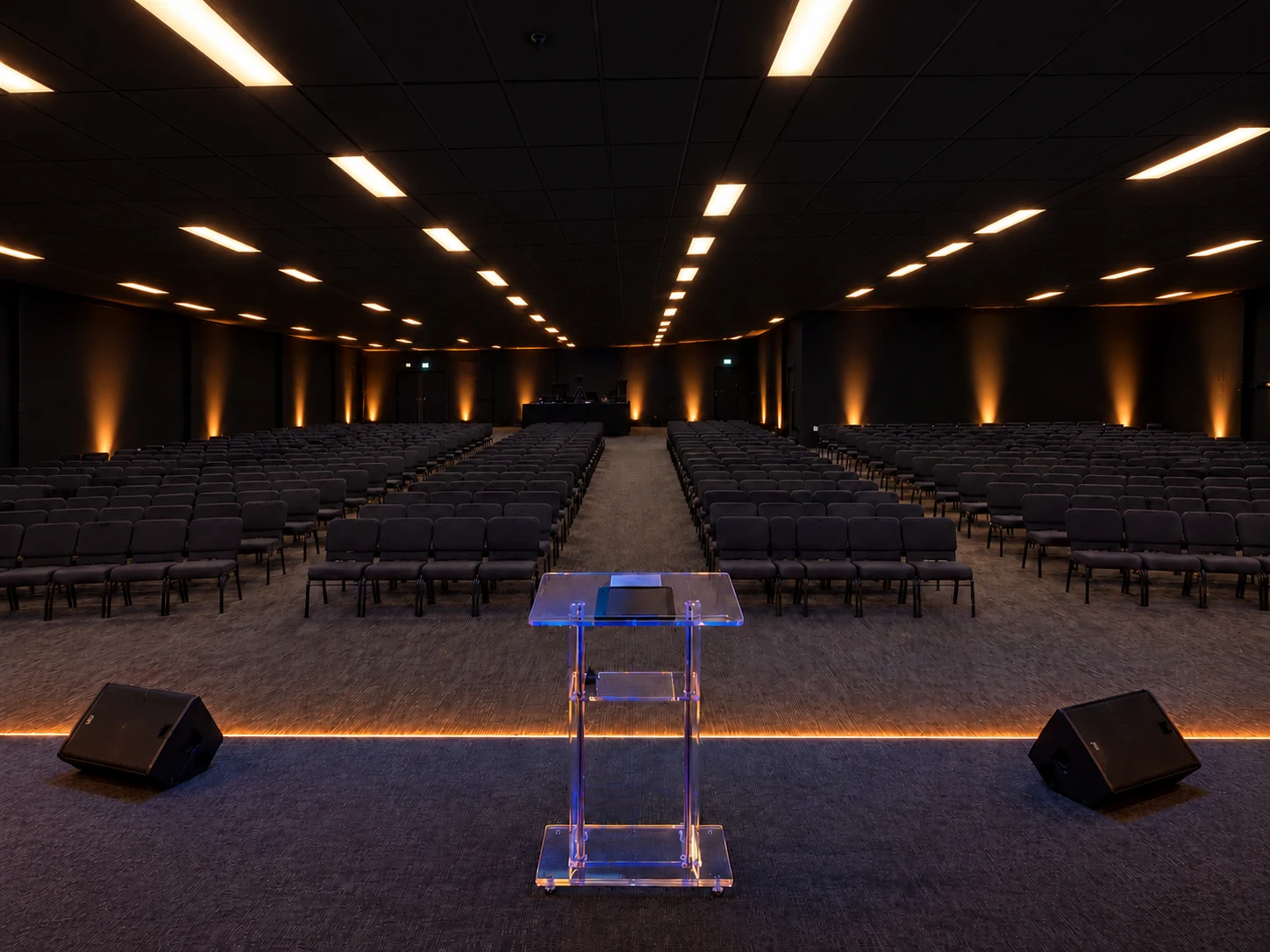 Projection de l’auditorium FBM avec plafond noir et éclairage chaleureux